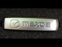 Эмблема Mazda из полированного алюминия для ковриков салона - 1 шт., 18х64 мм